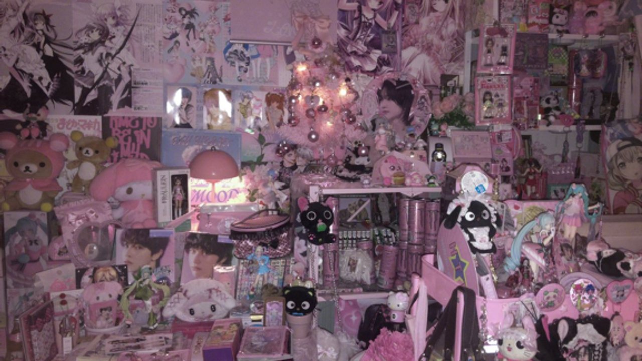 Cluttered pink cutecore bedroom wall packed with posters, lamps, and collectibles in maybe tomorrow ill open the door